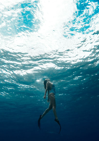 Girl diving in blue ocean